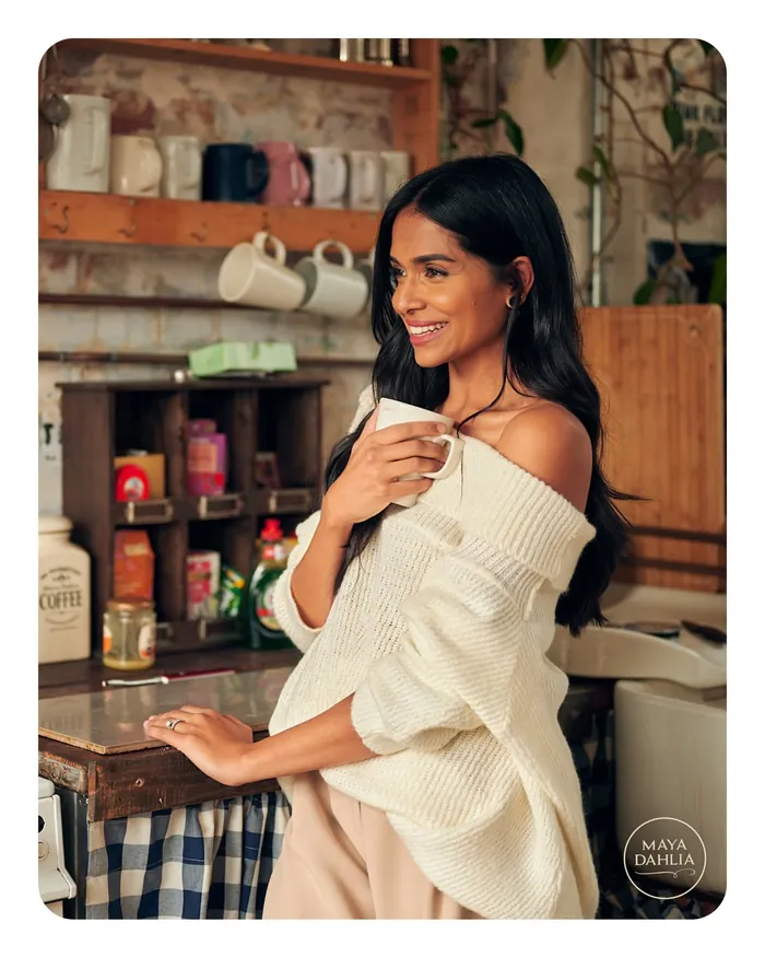 Krishma in the kitchen holding a mug, looking out of frame